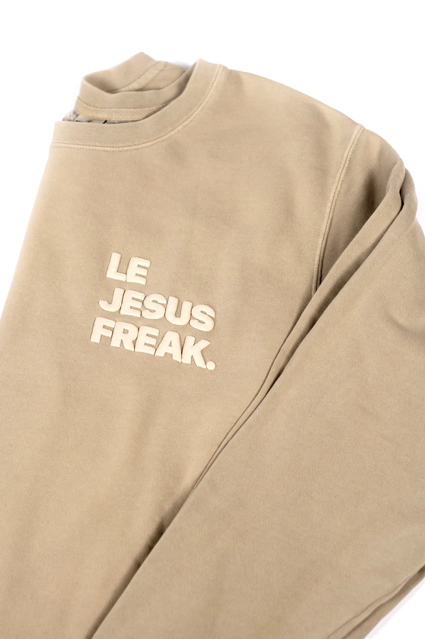 Beige sweatshirt with 'LE JESUS FREAK' text on a white background